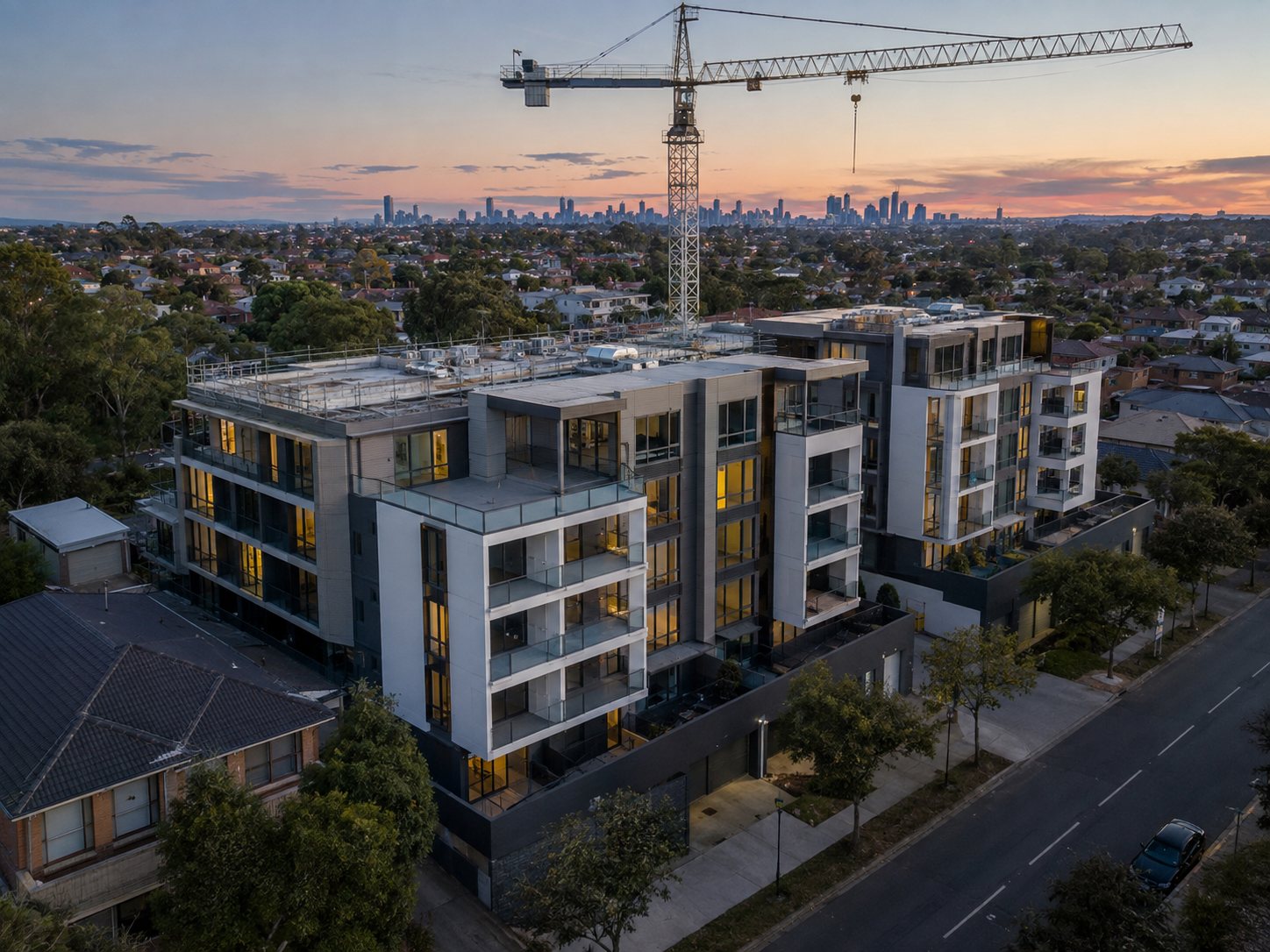 A mid-scale apartment development nearing completion at dusk
